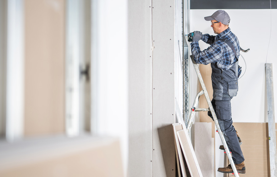 Worker putting up drywall